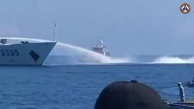 A China Coast Guard vessel blasts it's water cannon toward a Philippine Bureau of Fisheries and Aquatic Resources vessel near Panatag (Scarborough) Shoal this morning [December 9th 2023]