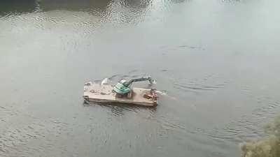 Excavator operating in the river