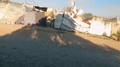 IDF armored bulldozer destroying structures in Khan Younis bursts through a wall and then is hit by a Hamas RPG.