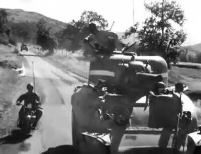 A soldier on a bike delivering a message to a Sherman TC.