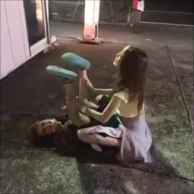 Two Japanese girls dry humping on the ground