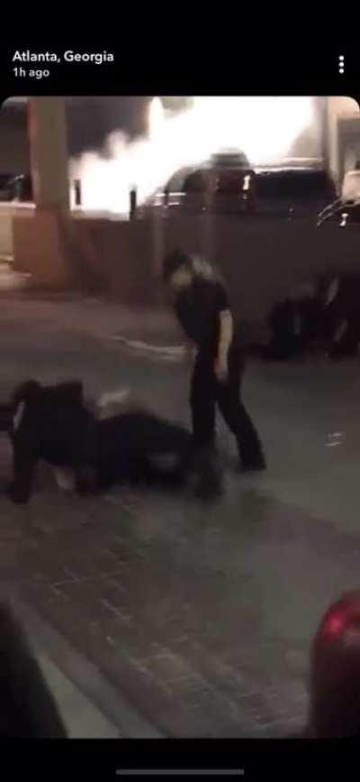 Cops stop punching person on the ground long enough to tackle woman who is walking away