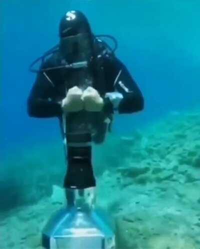 Diver bends air under-water to open cap 🤯