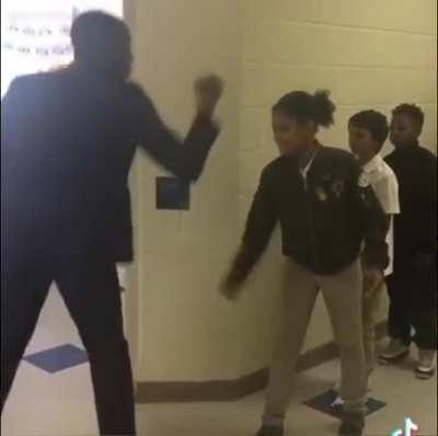 Teacher Barry White Jr giving each of his students their own unique handshakes.