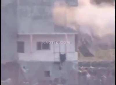 A guided missile hits a balcony with a Syrian soldier on it.