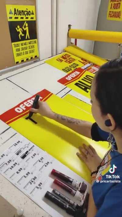 A talented calligraphy artist displays excellent penmanship as she makes signs for local stores