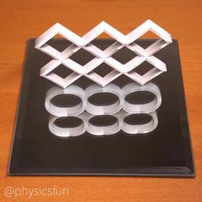 Illusion design by Kokichi Sugihara of Meiji University in Japan, the inventor of this illusion and art form. A mathematically calculated combination of perspective and the physics of reflection produces this striking