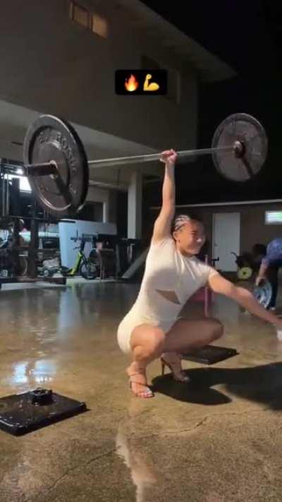 Olympic power lifter Stacia Camba does it one armed, in the rain, wearing heals