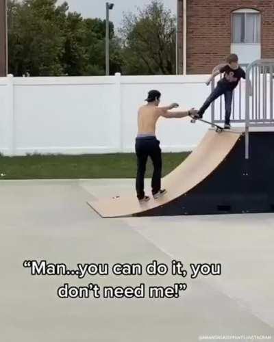 Guy at the skate park teaching kid to drop in