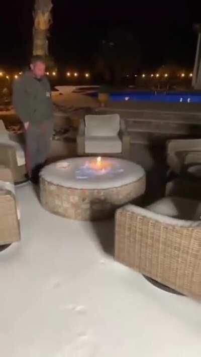 Guy Lights Frozen Fire Pit At the Back Porch Of His House