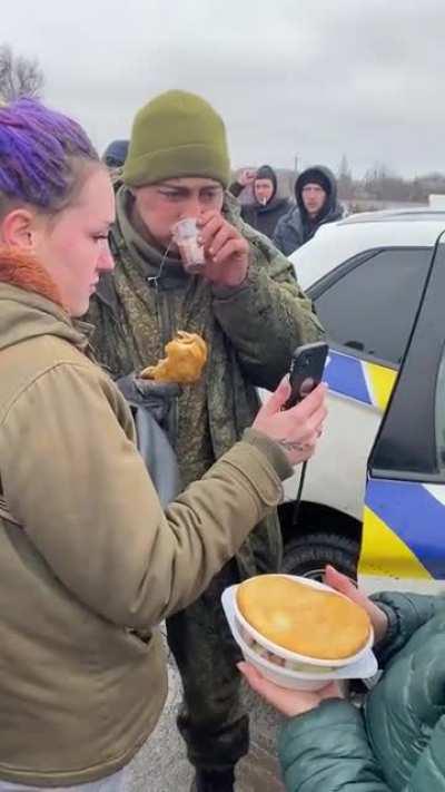 Ukrainians provide hot food and tea to a Russian soldier who voluntarily laid down his arms.