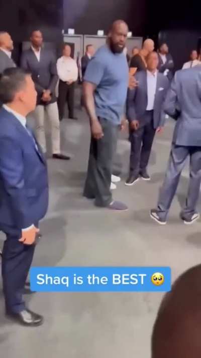 a young fan is escorted away by security after giving shaq a hug, after realising what happened shaq called him back over