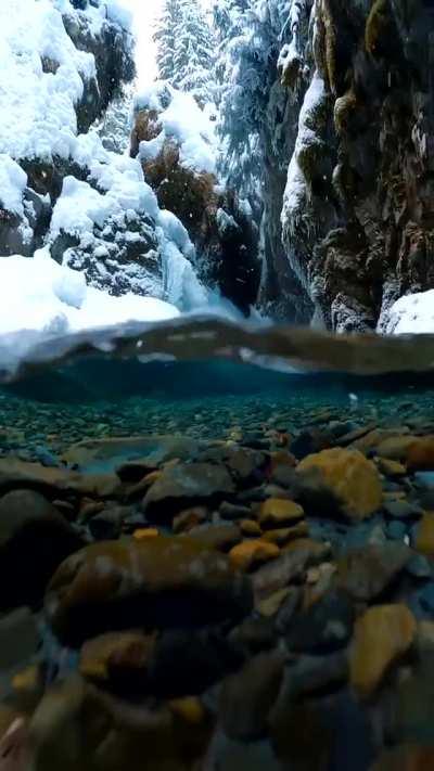 Snow falling on crystal clear Alaskan glacial melt water. Credit: Photographer John Derting