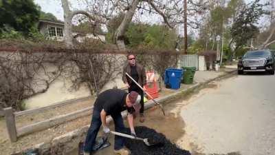 Tired of waiting, Arnold Schwarzenegger fills a giant pothole that’s been screwing up cars and bicycles for weeks