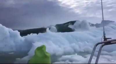 Boat trying to escape giant waves caused by falling ice.