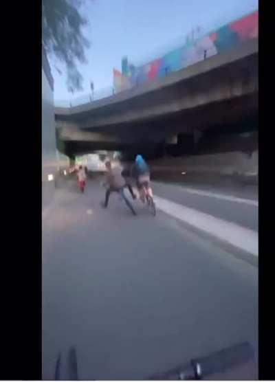 Idiot cyclists try’s to push kid doing wheelie and ends up falling off of his own bike