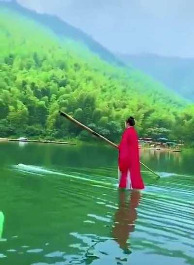 Riding a piece of bamboo like a stand-up paddle board