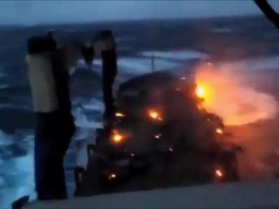 Cars getting transported on an open deck catch on fire after salty water shorts their batteries