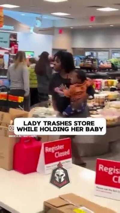 Woman trashes store while holding her baby