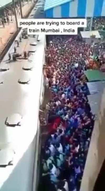 People in Mumbai trying to board a train.