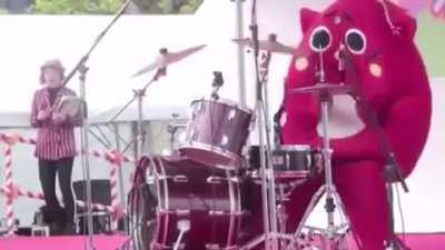 costumed person goes crazy on the drums at a children's concert