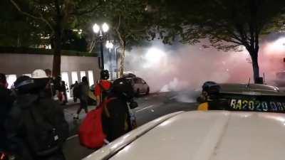 Protestors in Portland use smokescreens and fireworks to scare off a small group of officers