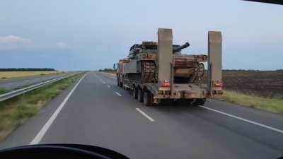 M1A1 SA-UKR Abrams equipped with a cage, Kontakt-1 and ARAT-1 transported on a truck