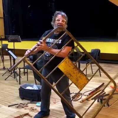 Spanish musician Xavier Lozano playing a flute made from a street barricade.