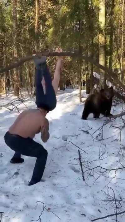 Two men working out with a bear