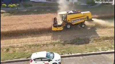 Polish farmer who refused to sell his land to developers harvests his field surrounded by apartments