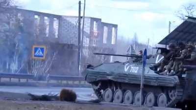 Russian soldiers atop a BMP-2 start aiming at a Ukrainian civilian recording.