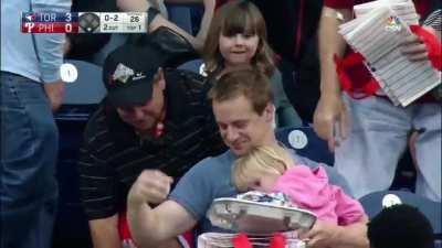 Fan catches foul ball while holding his child