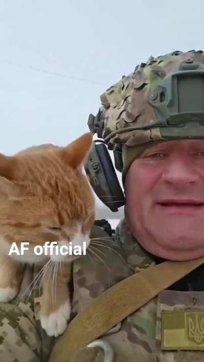 A Ukrainian soldier with his shoulder-mounted tactical battle cat.