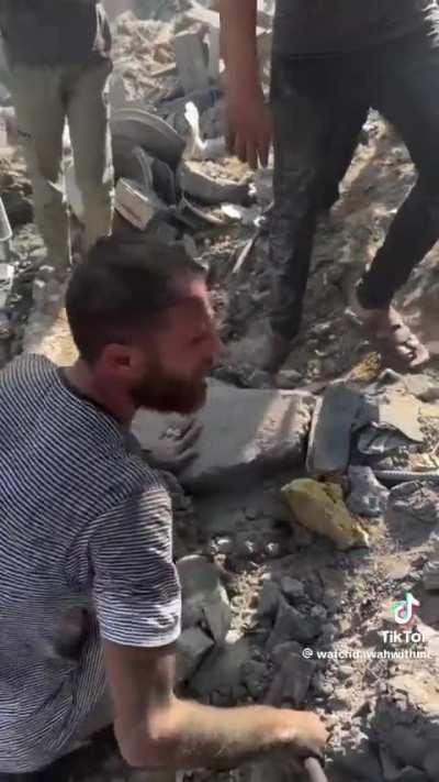 Gazan father looking through the rubble for his children's bodies. 