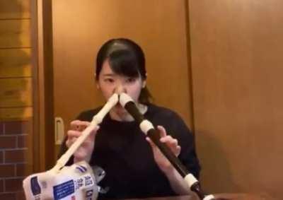 This girl plays two recorders at the same time with her nose