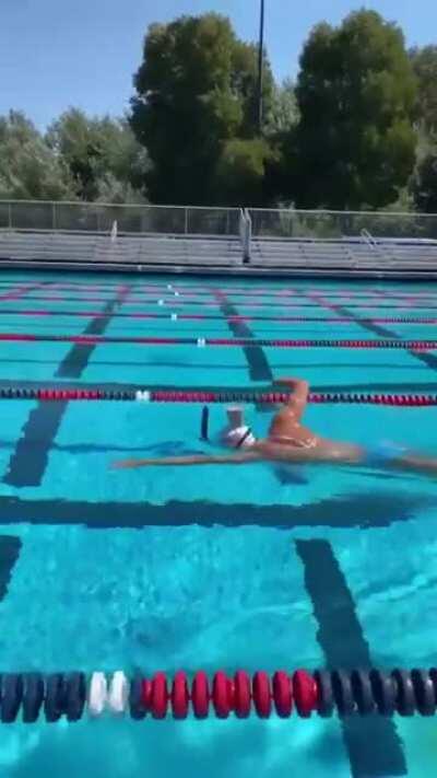 Olympic swimmer keeps head so steady while swimming a glass of chocolate milk placed on the back of her head doesn't spill a drop