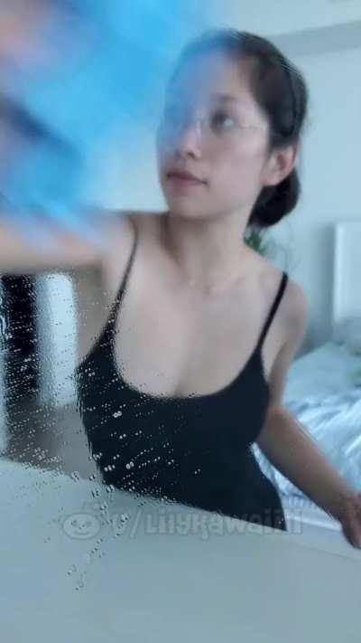 Asian cleaning the mirror