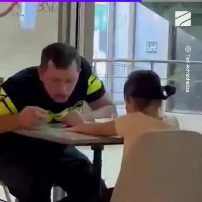 Policeman with his daughter in cafe