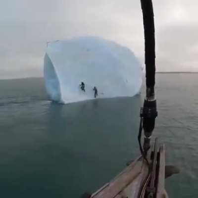 Iceberg flips over as some people try to climb it