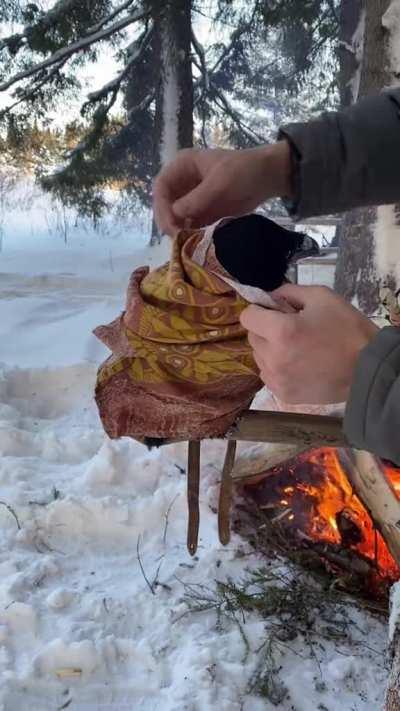 This guy covering his pet raven up with a blanket on a wintery day