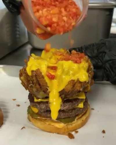 Double cheeseburger topped with a blooming onion, filled with nacho cheese, and garnished with flaming hot Cheetos. Good luck eating it!