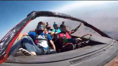 Team of skydivers Drive a Toyota Corolla FX out of a plane then float above Arizona desert before parachuting to the ground.