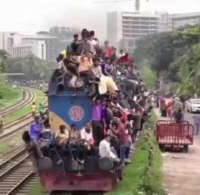 Extremely overcrowded train with passengers inside and of the train roof in Bangladesh