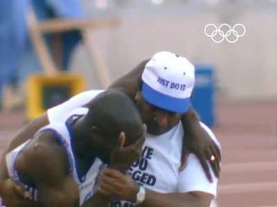 The father who helped his son cross the finish line at the Olympics has died