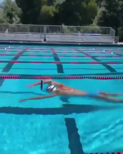 Olympic Gold Medalist, Katie Ledecky, swims with a glass of chocolate milk on her head