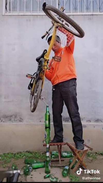 balancing a fucking bike on top of 3 glass bottles