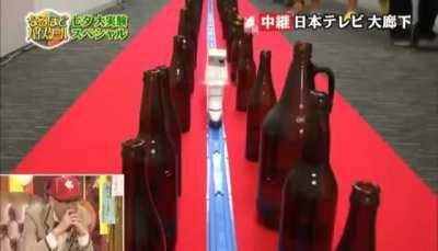 Placing the different size bottles along a model train path to hammer out a tune