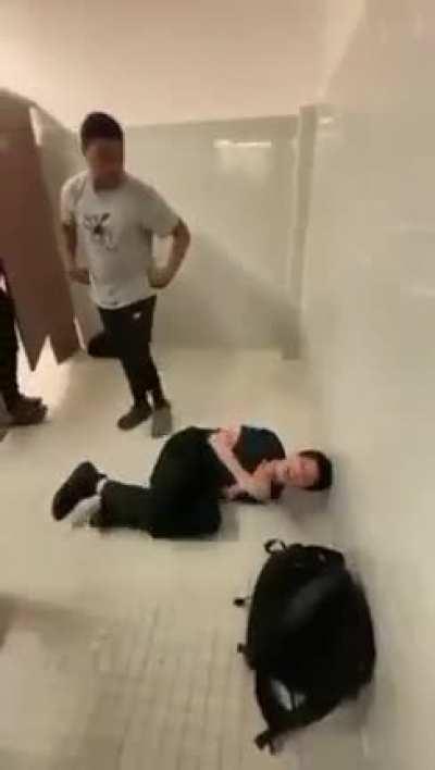 Kid thrown and kicked in middle school bathroom