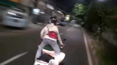 Indonesian police chase gang members on scooters while shooting at them one handedly using a rifle