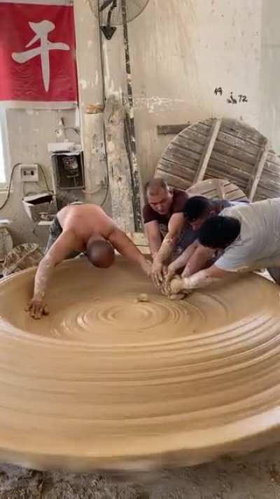 Potters working giant clay ware in factory in Jingdezhen China